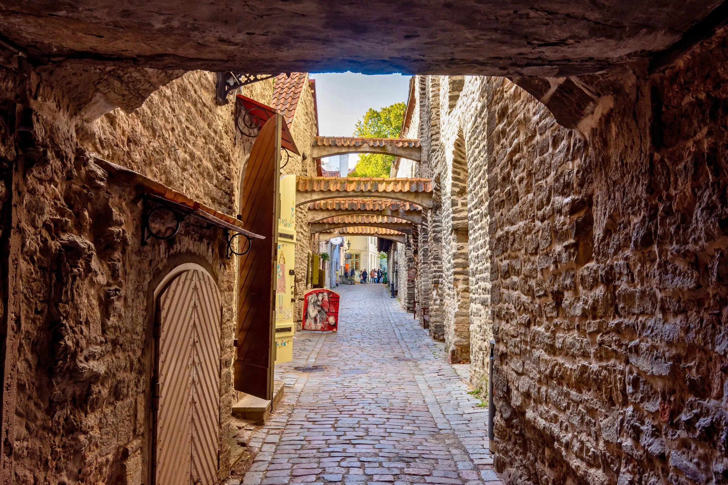 Stone arches crossing the narrow cobblestone street of St. Catherine's Passage in Tallinn