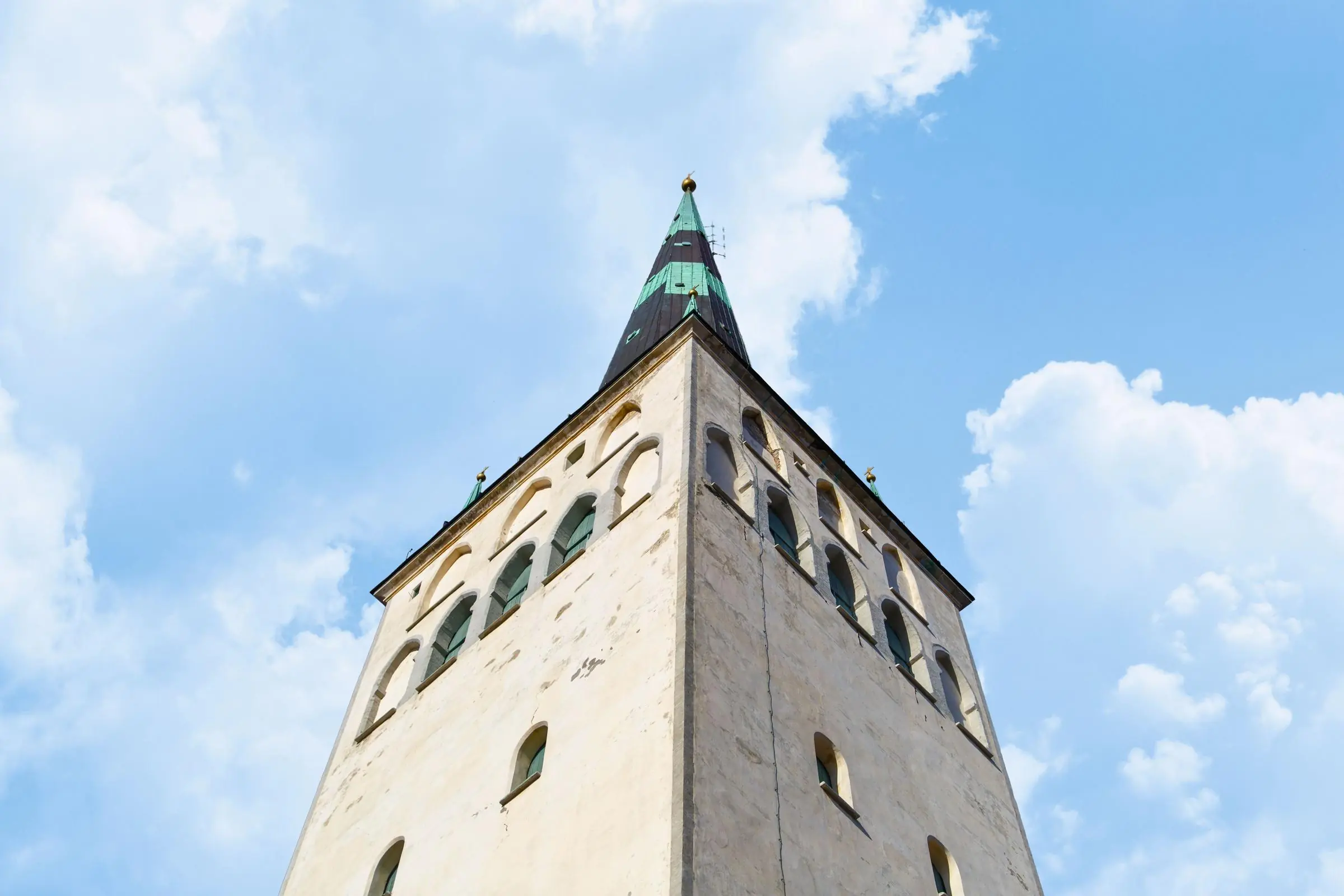 The towering spire of St. Olaf's Church rising above the red roofs of Tallinn Old Town