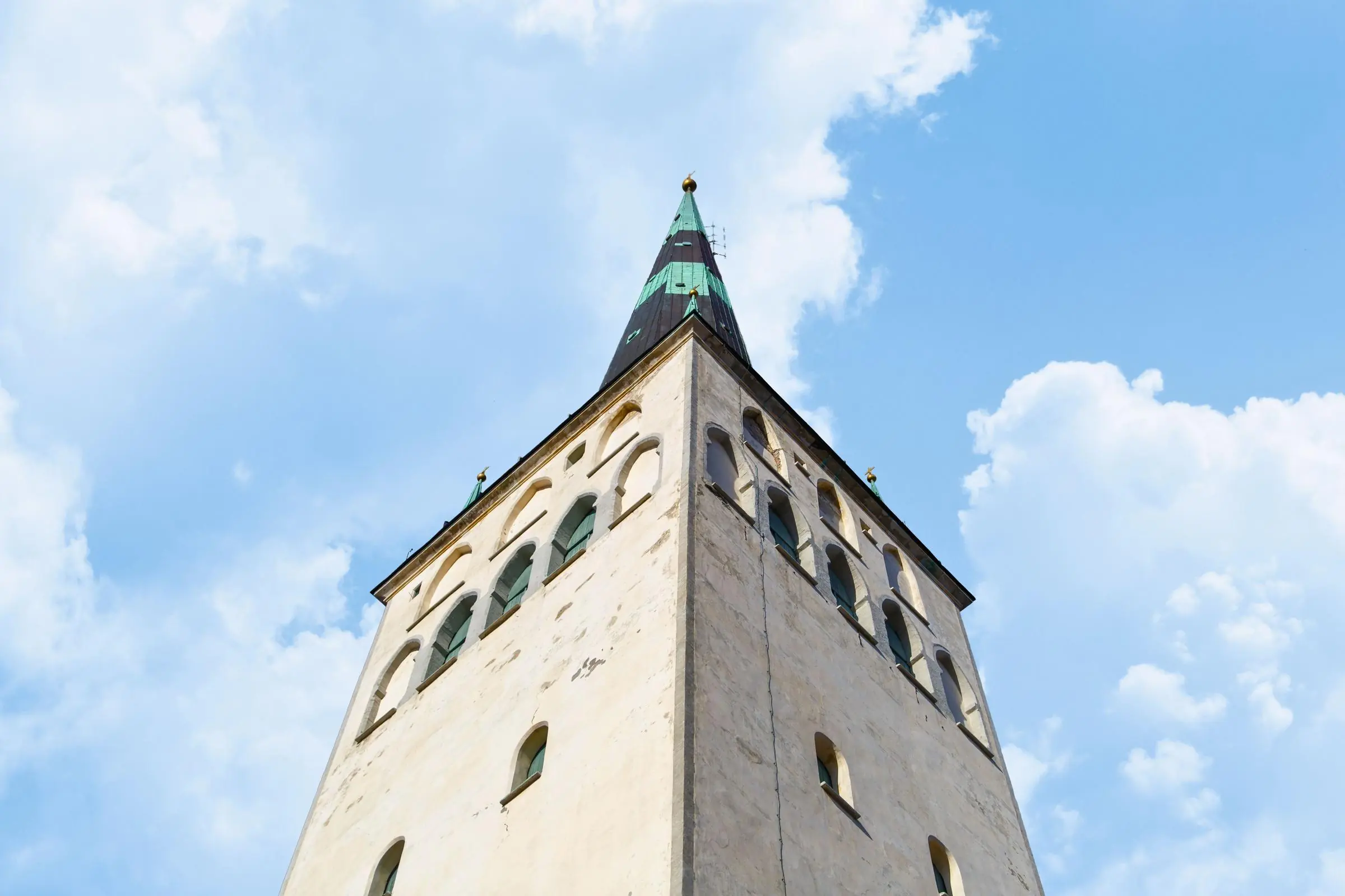 The towering spire of St. Olaf's Church rising above the red roofs of Tallinn Old Town